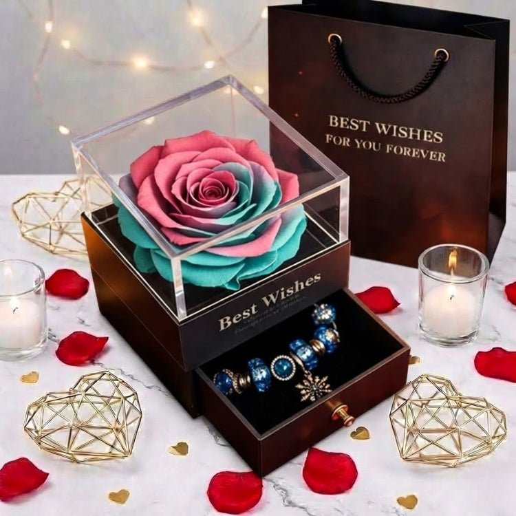 A unique pink and turquoise ombre eternal rose jewelry box, surrounded by gold heart decorations and candles.