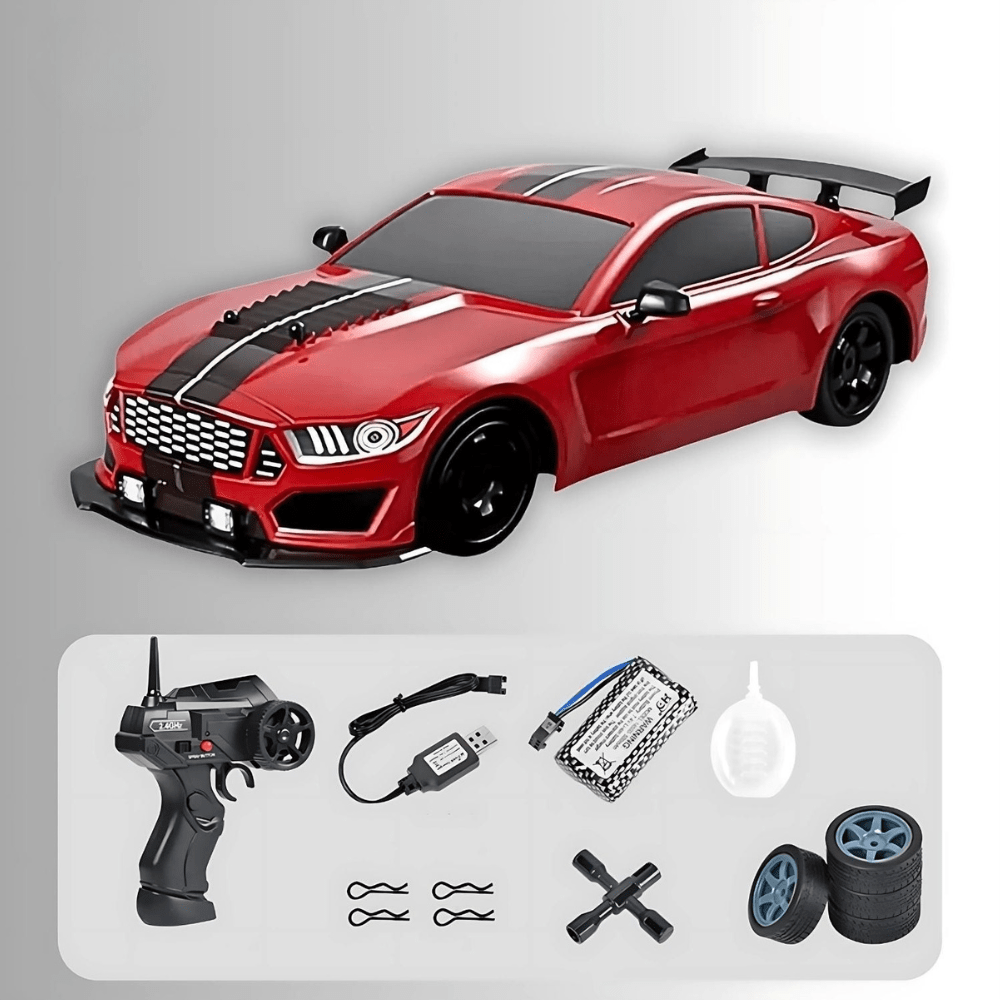 red drift RC car with racing decals displayed with a remote, spare tires, cones, and drums.