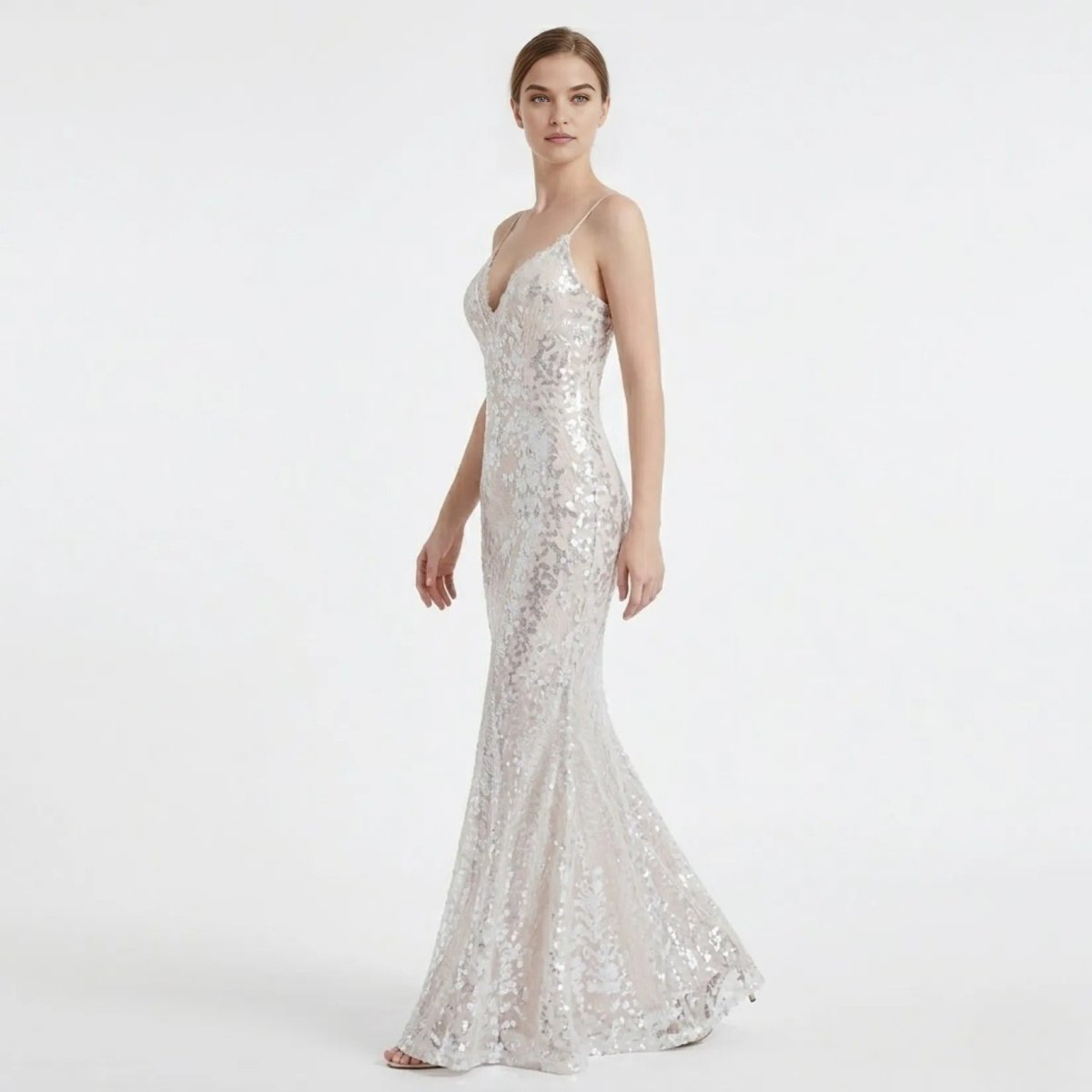 Side angle profile of a woman in a sparkling white sequin maxi prom dress, showcasing the form-fitting bodycon silhouette and thin spaghetti straps.