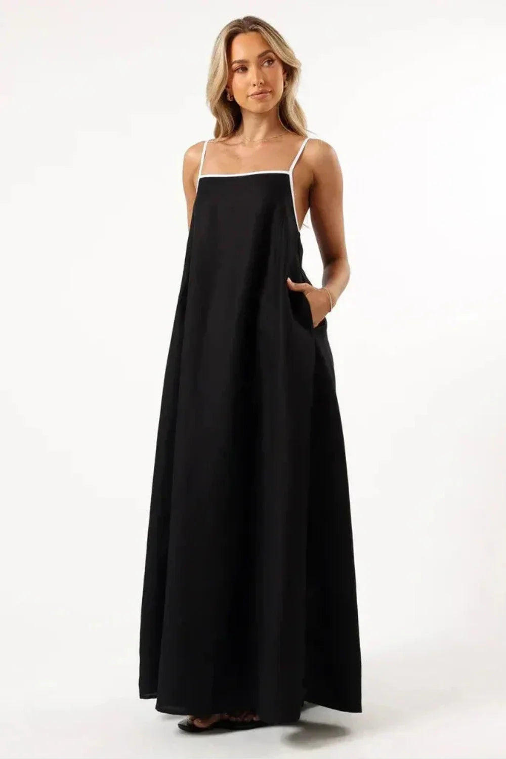 Model wearing Kouvr Fashion black linen maxi dress with white tie-back straps