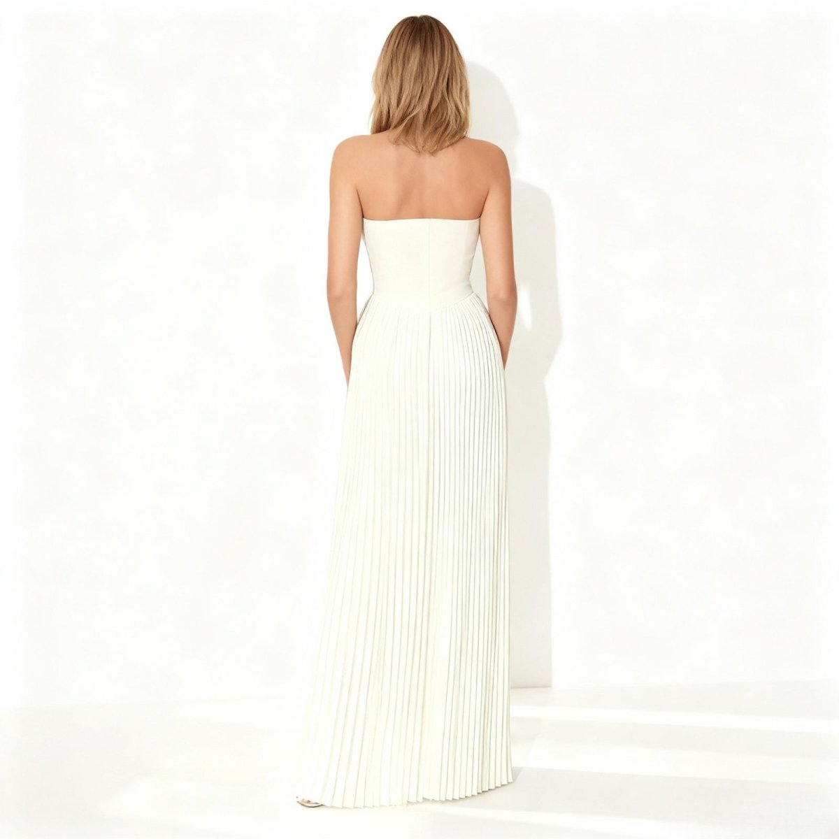 Woman wearing a ivory kouvr strapless dress on a white background