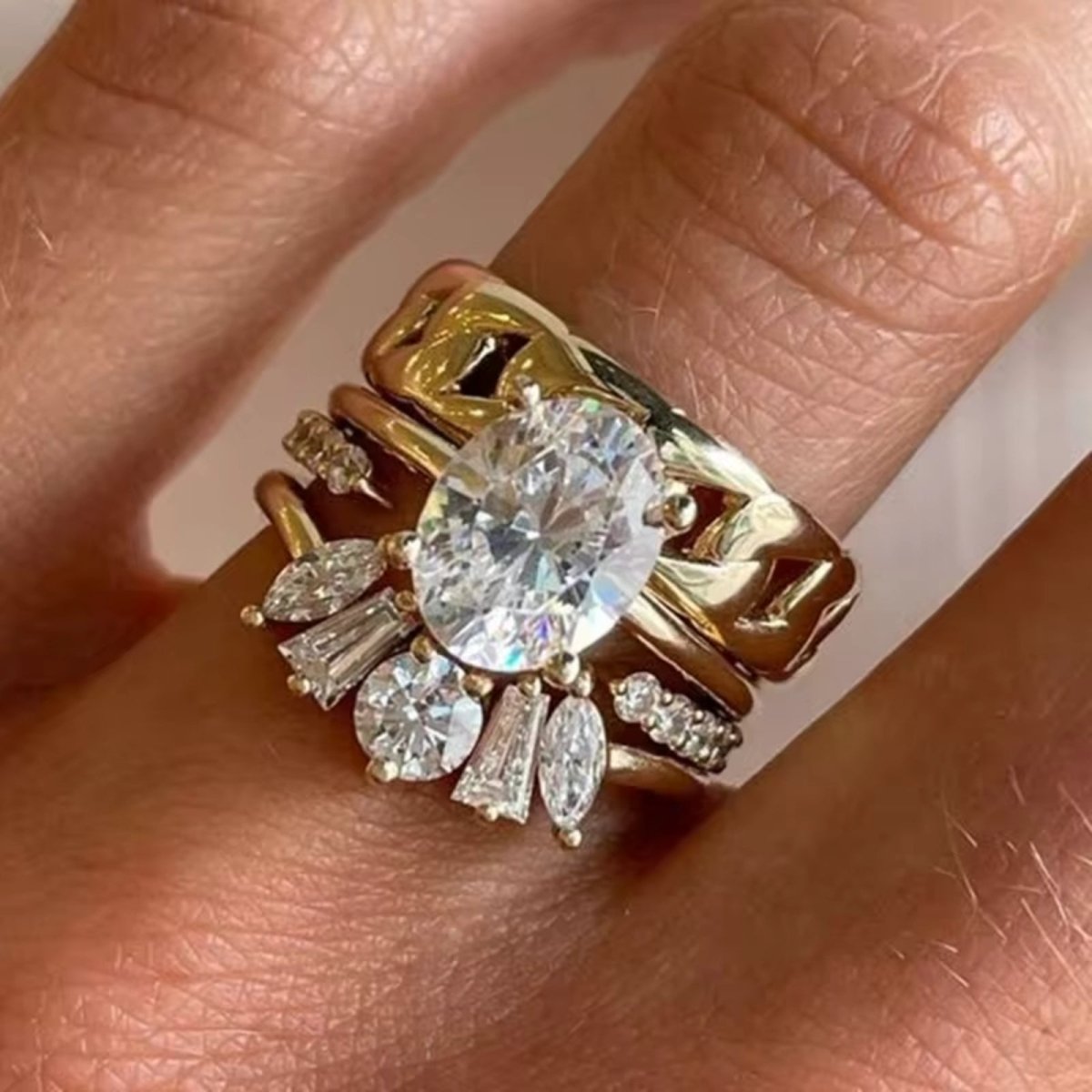 Detailed close-up of the Kouvr Emersyn oval diamond ring stack, showing the brilliance of the marquise, baguette, and round accent diamonds.