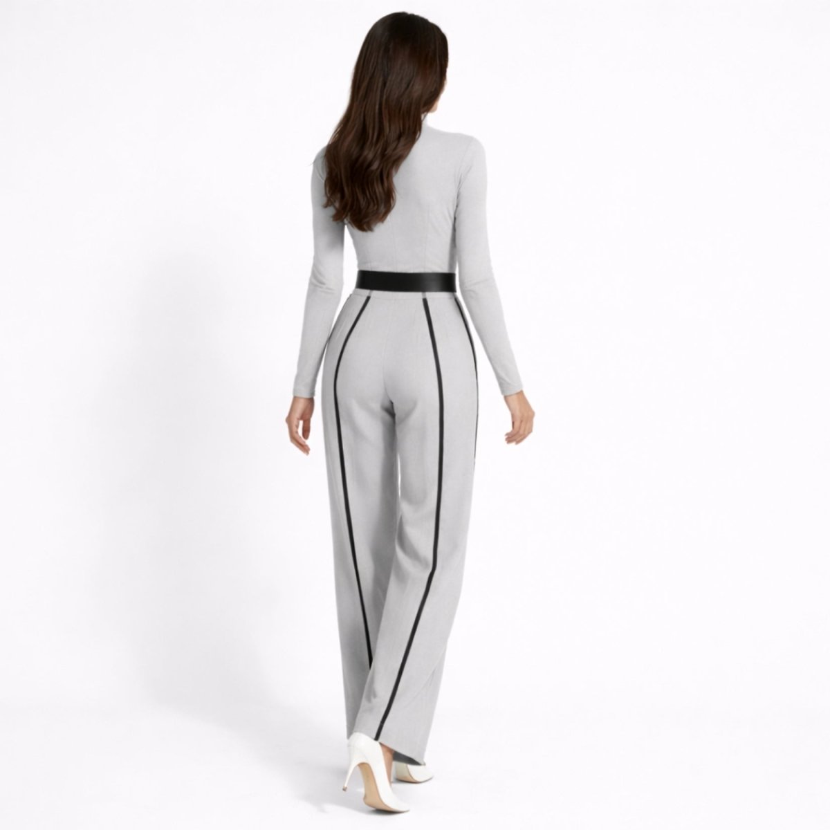  Back view of female model wearing the Kouvr grey long sleeve jumpsuit highlighting the back contrast piping, waist belt, and wide leg fit.
