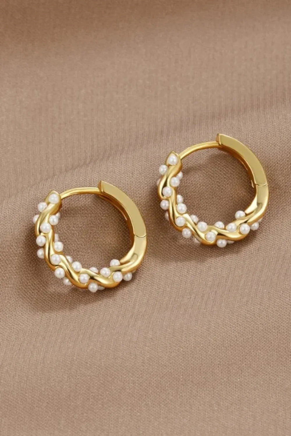 Model wearing Kouvr Kim small 18k gold pearl huggie hoop earrings