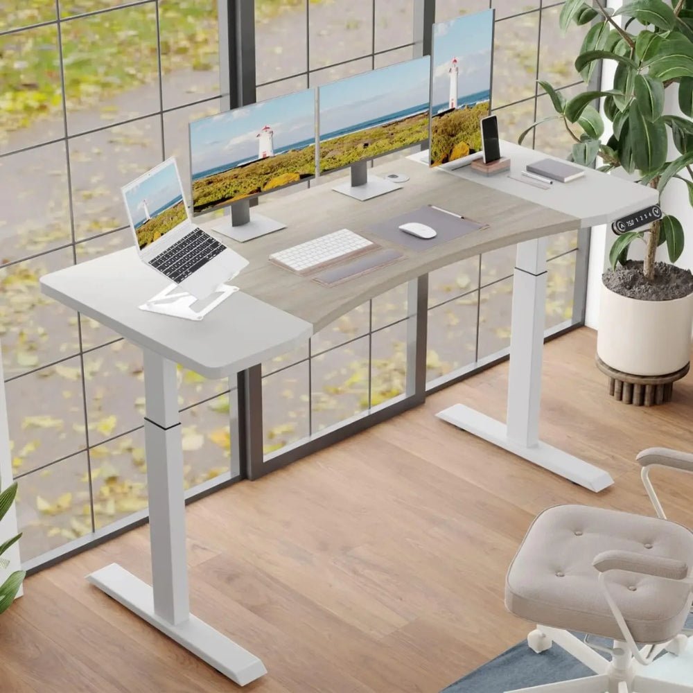 Modern office setup with a Kouvr adjustable desk, computer monitors, and a chair.