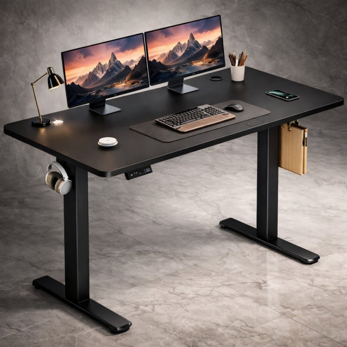 The all-black Kouvr height adjustable desk featuring a sleek black top and matching frame, styled with dual monitors and a desk lamp.
