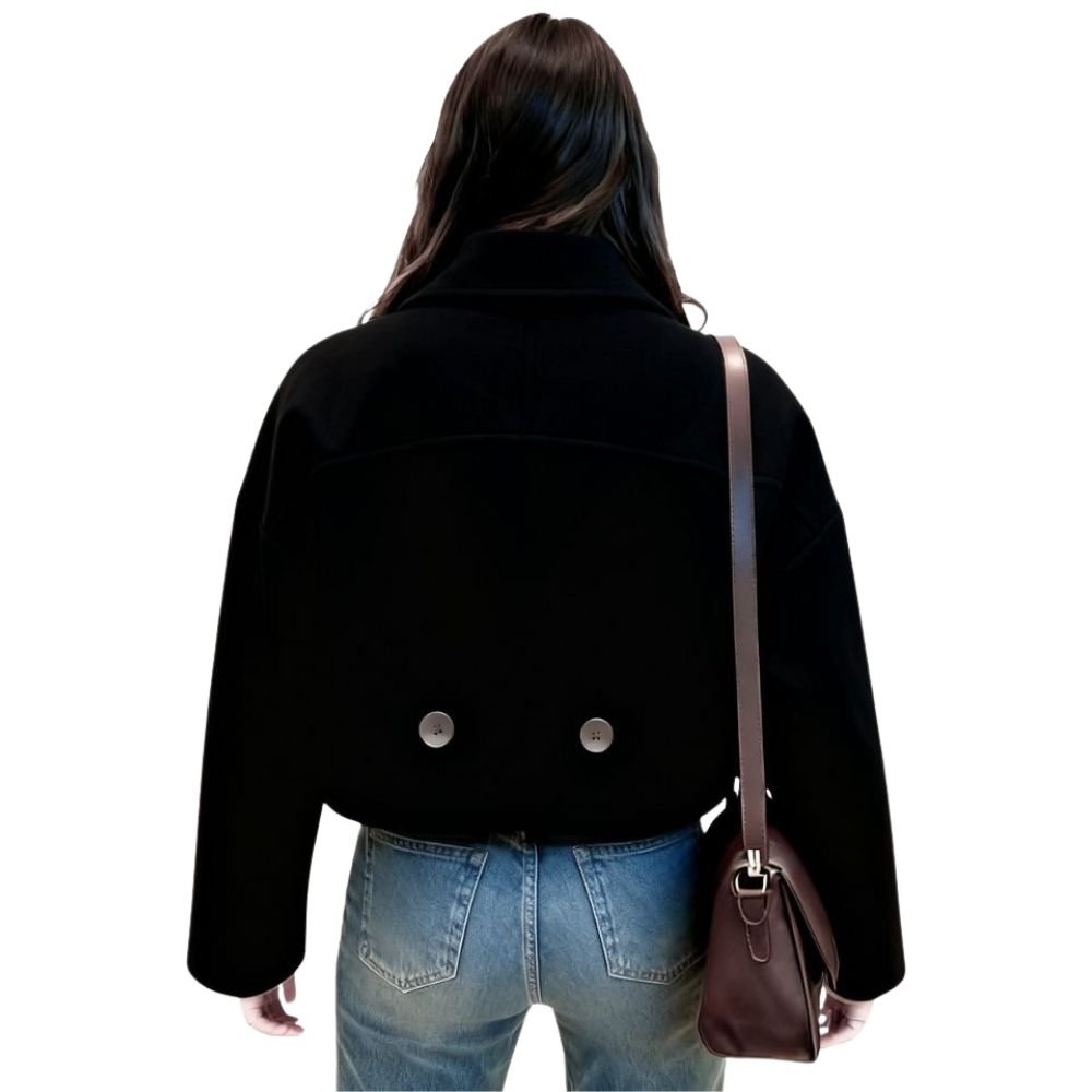 Back view of the Kouvr black cropped wool jacket on a model, showing the clean back yoke seam and two decorative lower buttons.