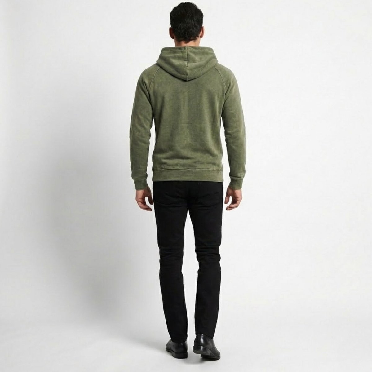 Back view of a male model wearing the olive green Kouvr Cannon hoodie, showcasing the hood and raglan sleeve construction.