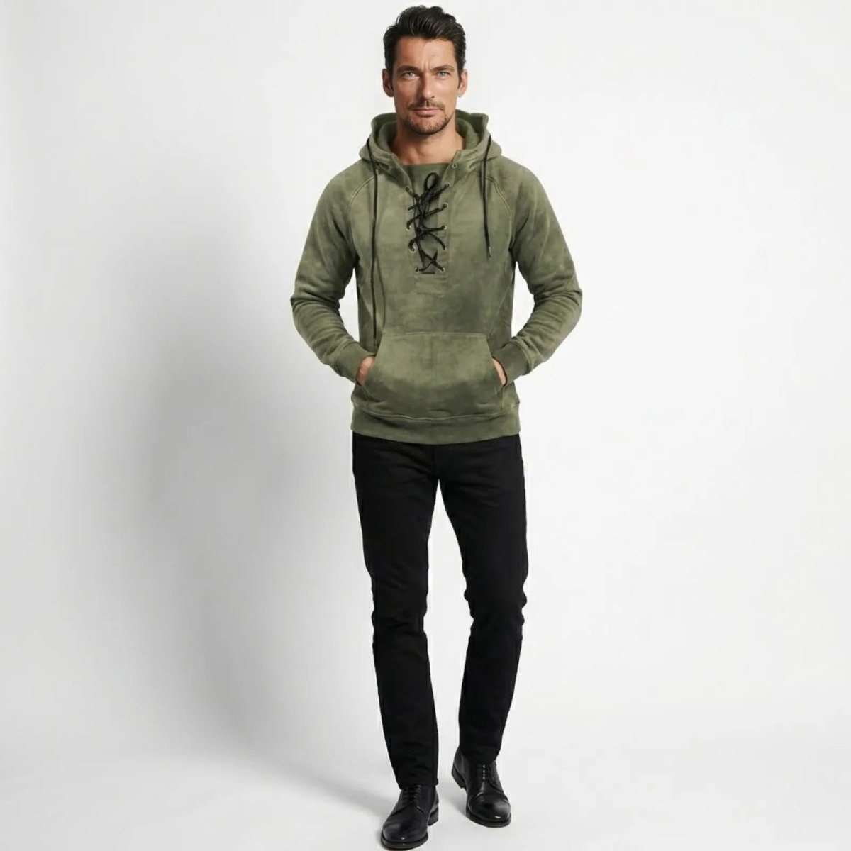 Male model wearing the Kouvr Cannon lace-up hoodie in olive green, styled with black jeans and facing forward.