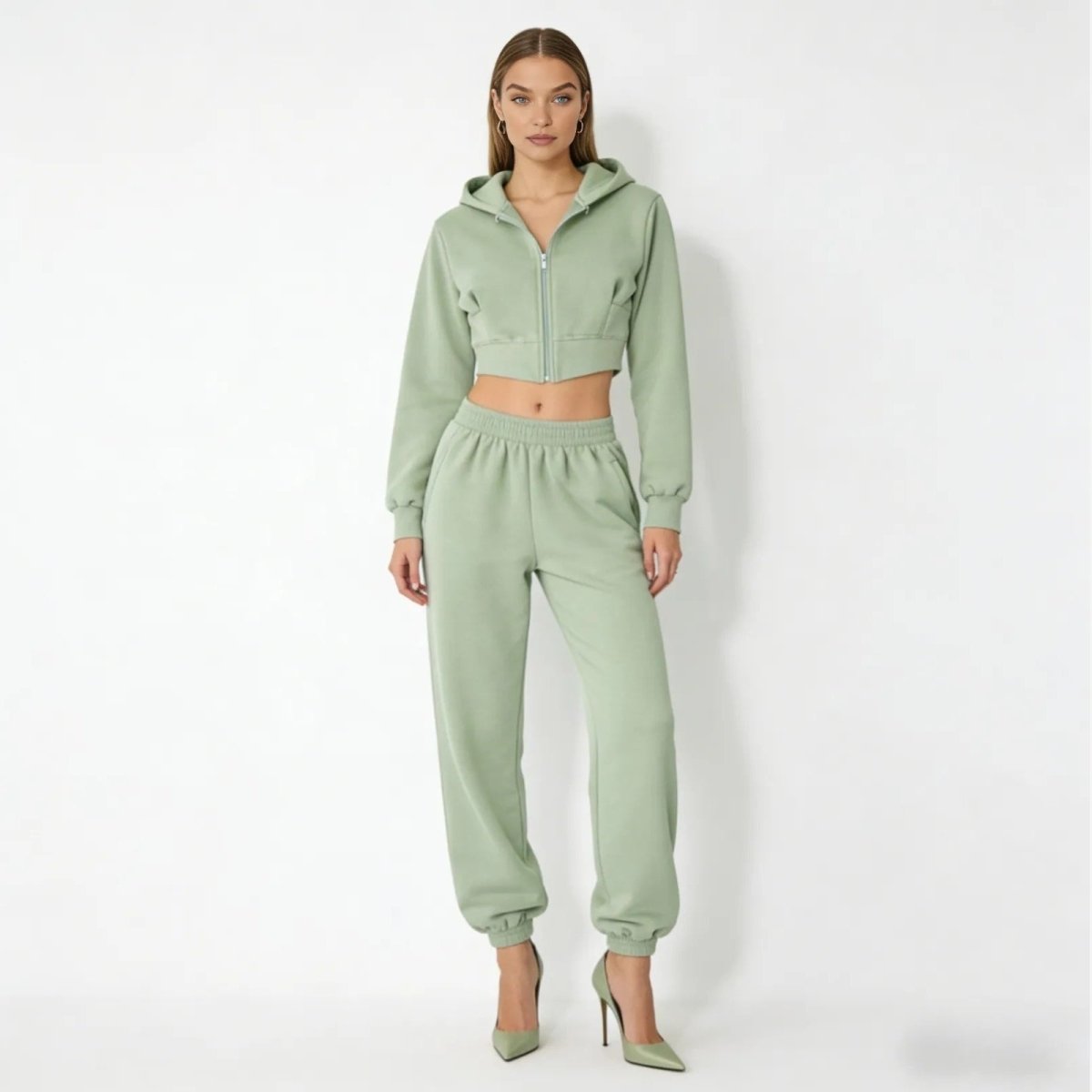 Model wearing the Kouvr Fashion green structured corset zip hoodie and matching high-waist fleece joggers, front view.
