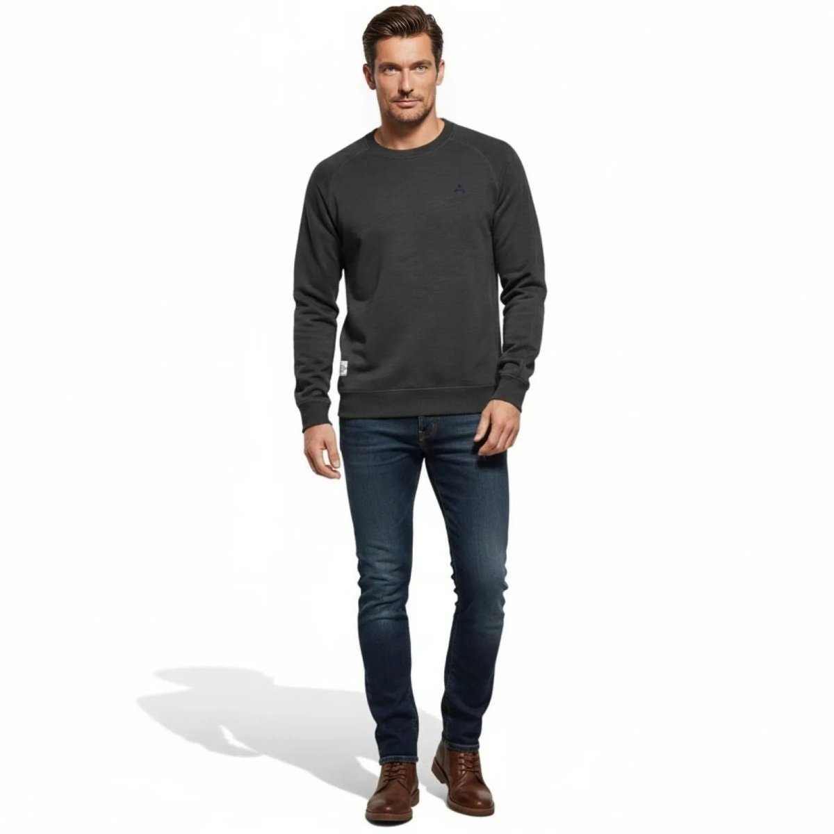 Man wearing the slim fit Kouvr Deacon Crewneck Sweatshirt in charcoal grey with dark wash jeans, front view.