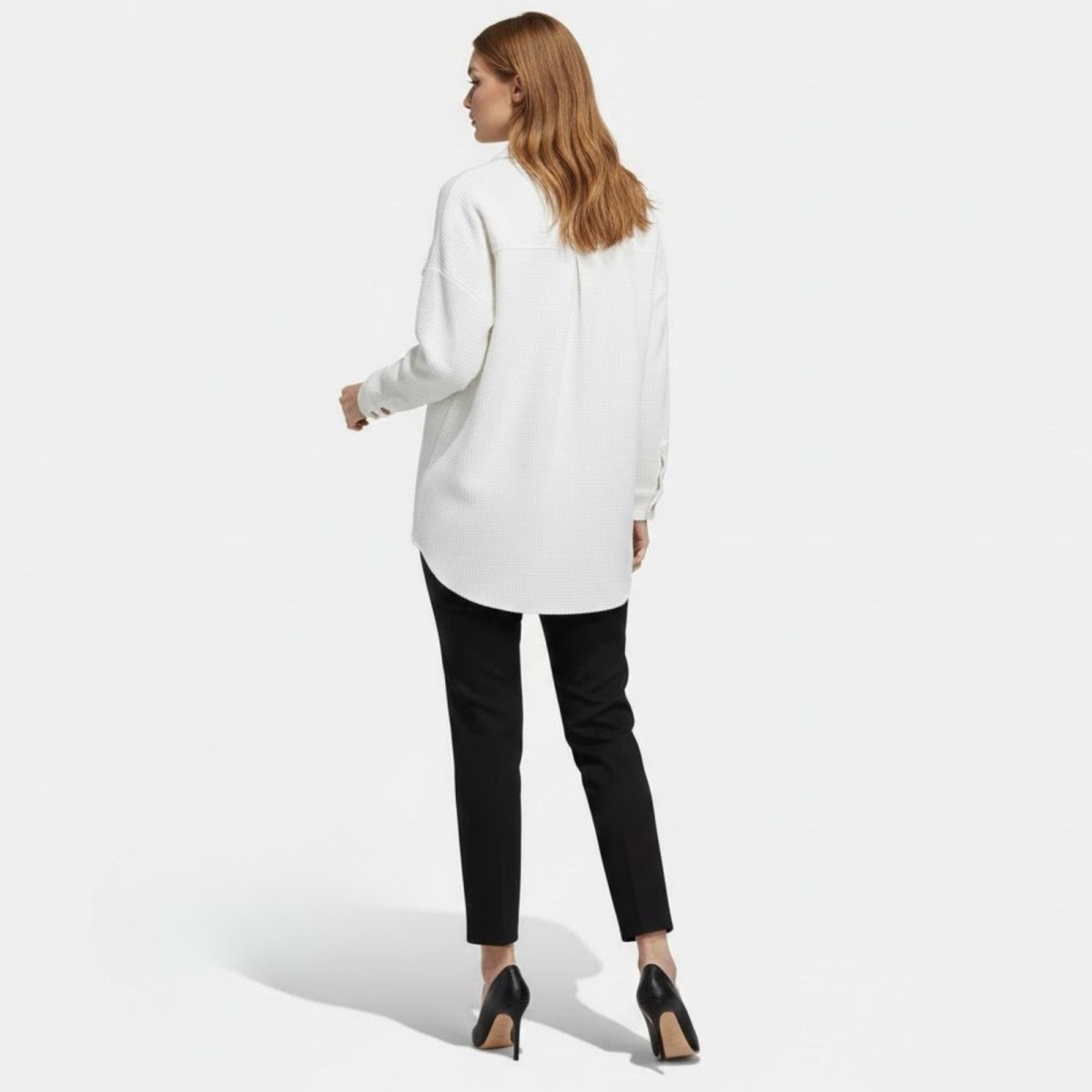  Back view of the Kouvr Donna textured shacket in white, highlighting the curved hem and clean, structured tailoring on a model.

