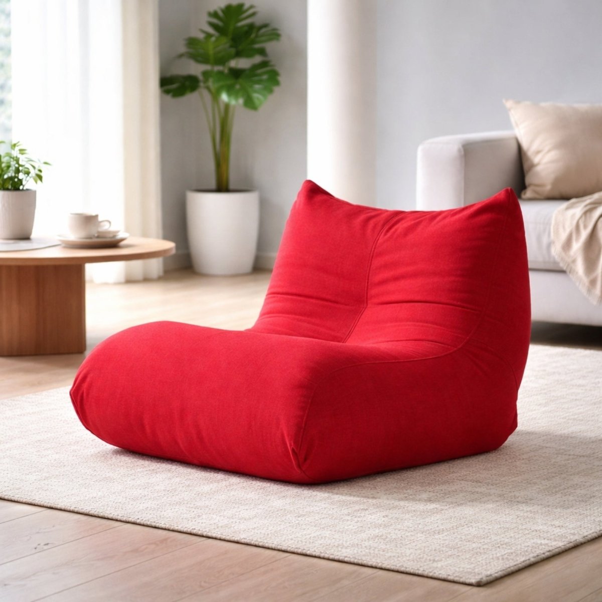 Side view of red tufted floor recliner showing ergonomic back support and pleated fabric detailing.