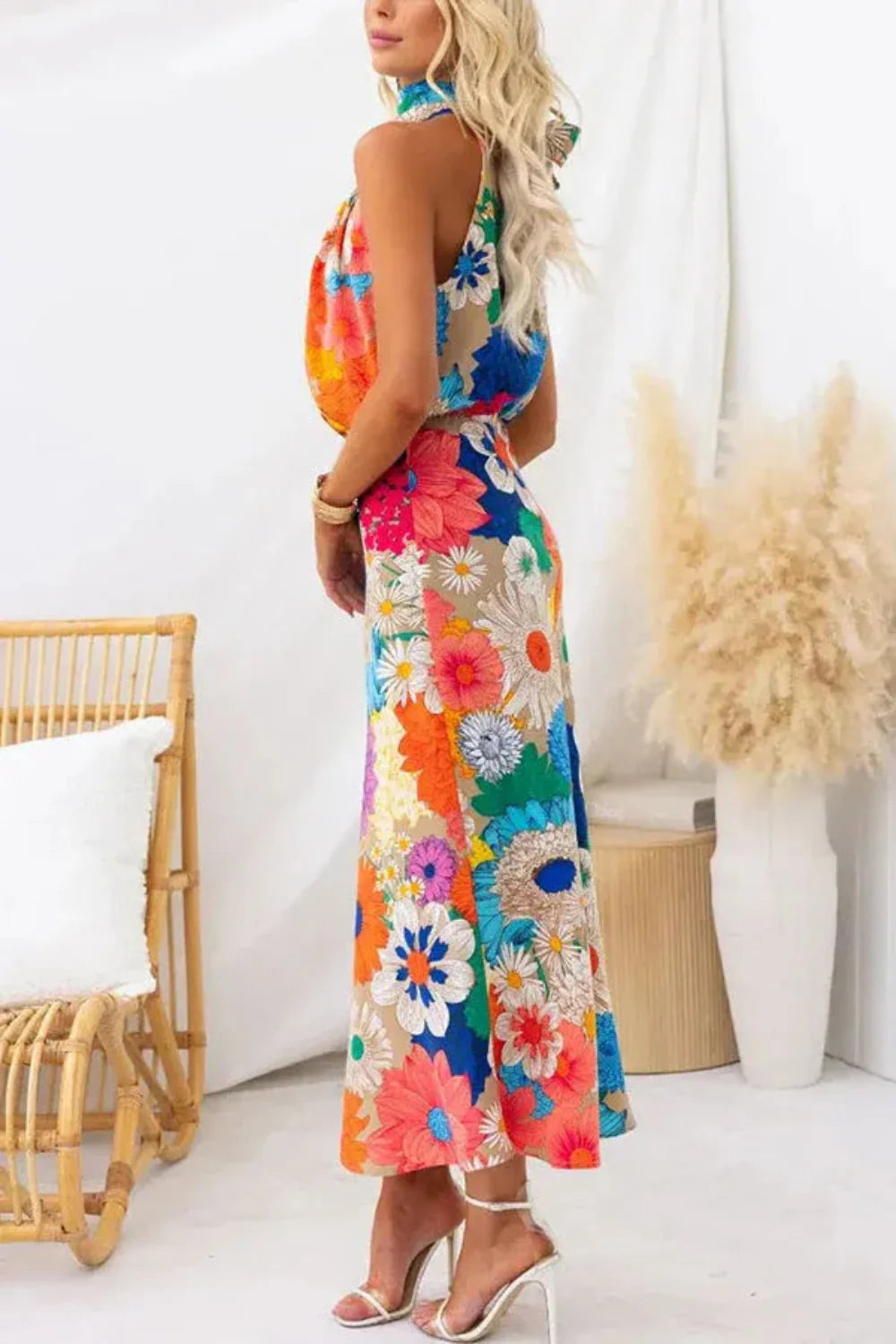 Model wearing the Kouvr Elisha colorful floral halter maxi dress in a bright room