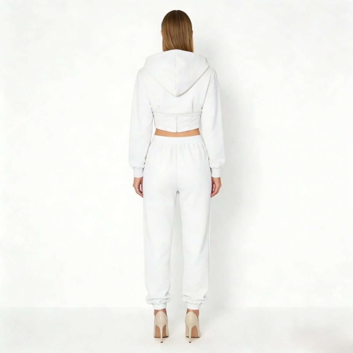 Back view of the Kouvr Ellaine white sweatsuit, highlighting the structured waist detail of the cropped hoodie and the clean lines of the joggers.