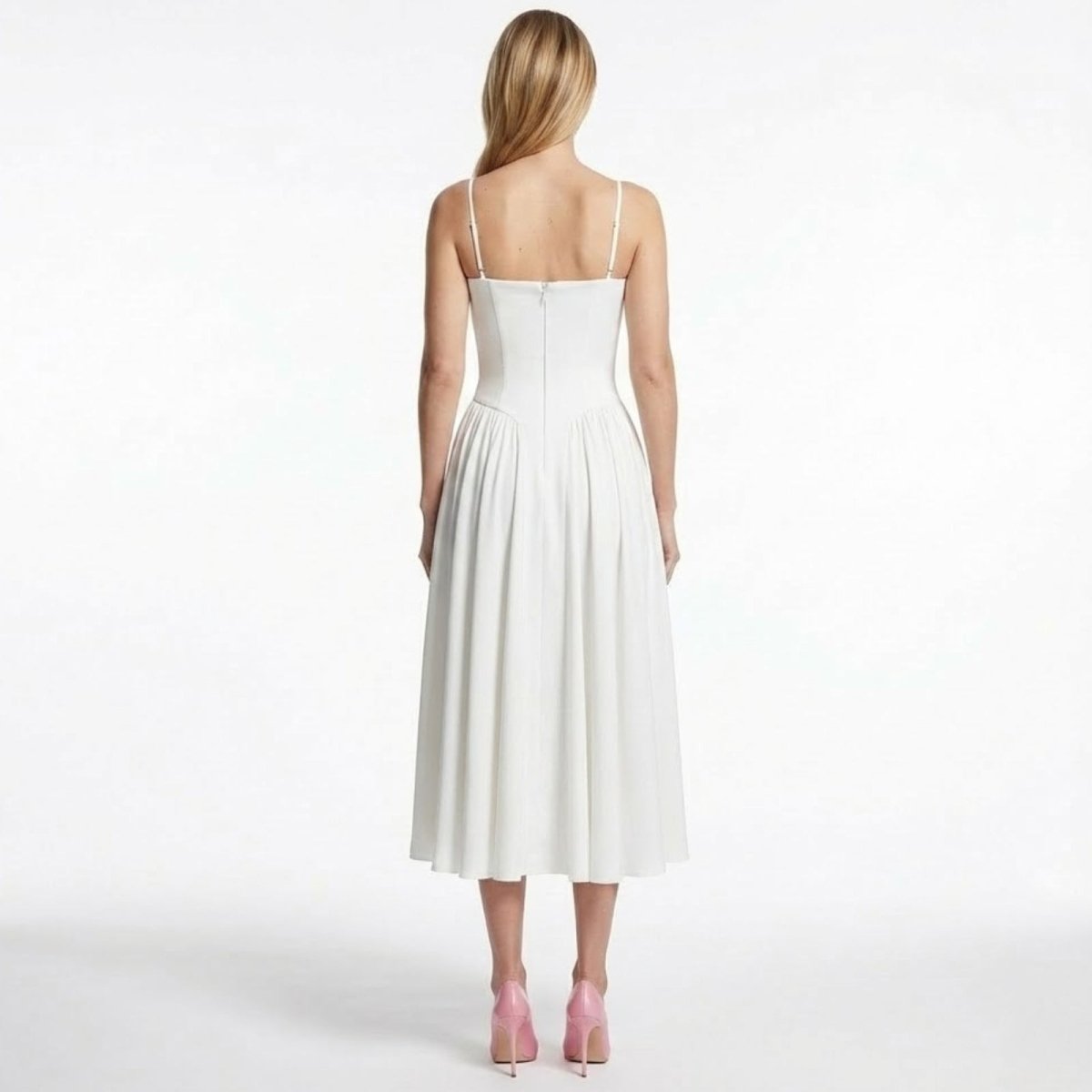 Back view of the Evdokia white bustier dress by Kouvr Fashion, displaying the spaghetti straps and concealed zipper detail.
