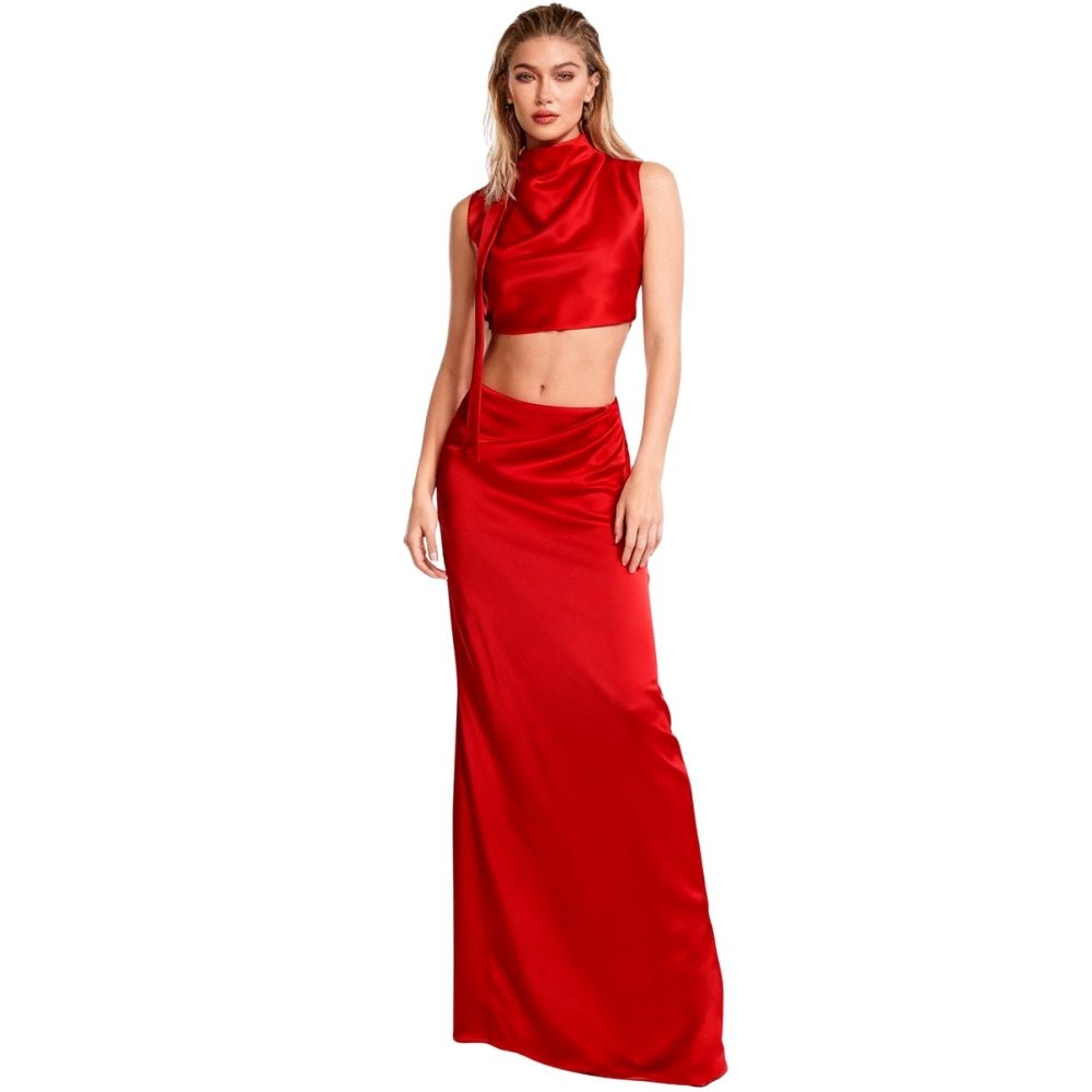 Model wearing the Evelyn red satin two-piece set, featuring a high-neck open-back crop top and matching maxi skirt by Kouvr.