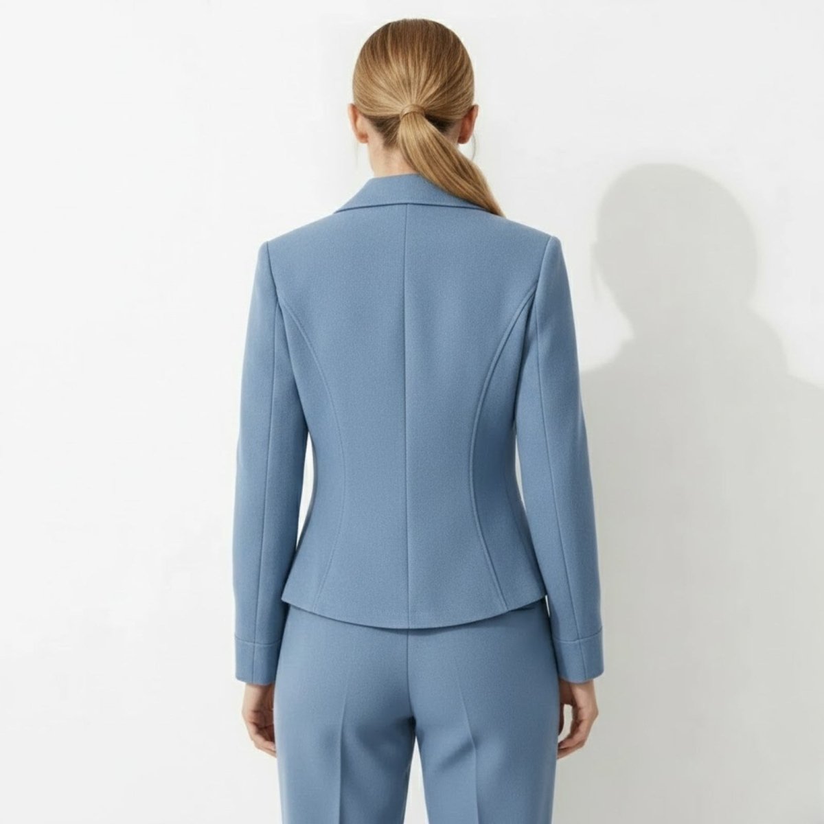 Back view of the Kouvr Fashion blue blazer highlighting the tailored princess seams and cinched waist design.