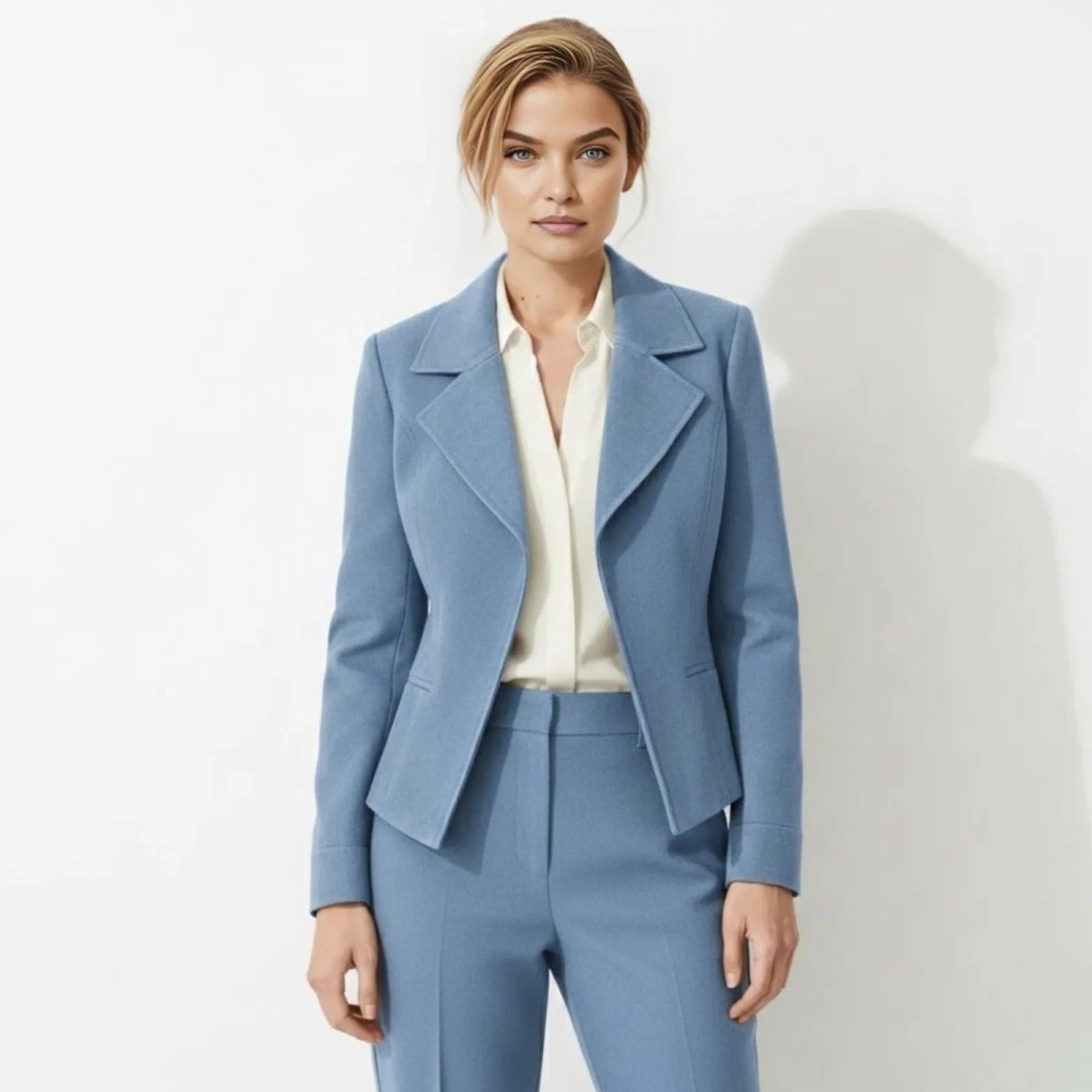 Woman with blonde hair wearing the Kouvr Fashion blue structured cropped blazer and matching trousers, facing forward. 