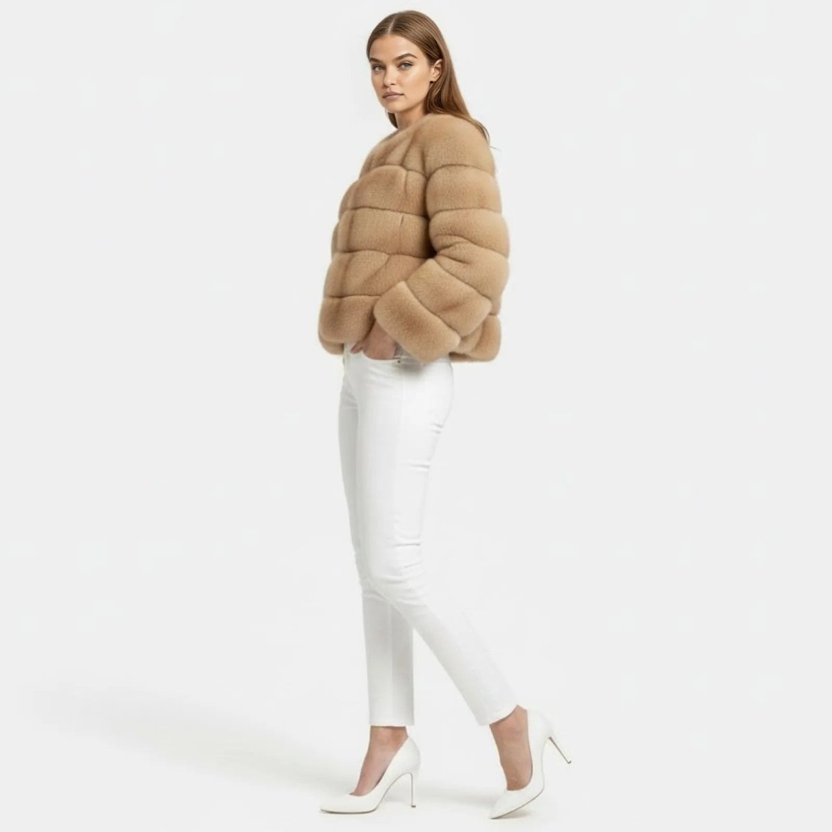 Side profile of a model in a plush camel faux fur bubble jacket showing its cropped length.