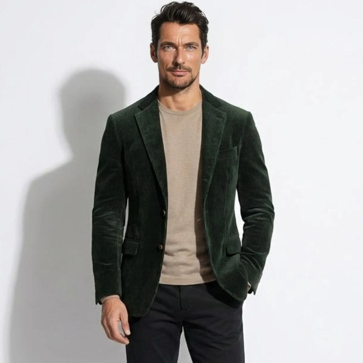 Model wearing the Kouvr Fashion men's dark green grady blazer with a beige t-shirt and black trousers, showcasing its slim tailored fit.