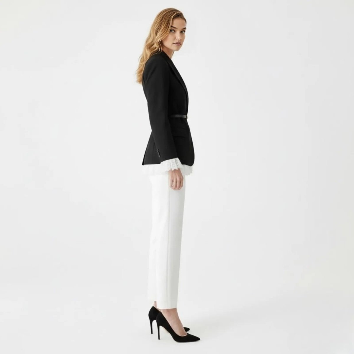 Side profile of a model in the Kouvr Fashion black belted blazer, highlighting the tailored silhouette and lace cuff detail.