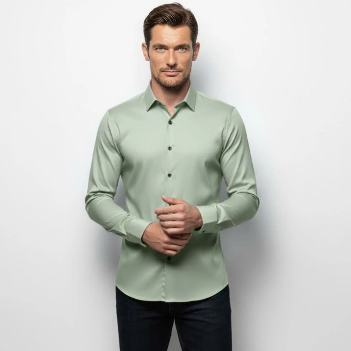 Male model wearing the Kouvr Fashion Light Green Slim Fit Stretch Dress Shirt, front view showcasing the tailored fit and contrasting dark buttons.