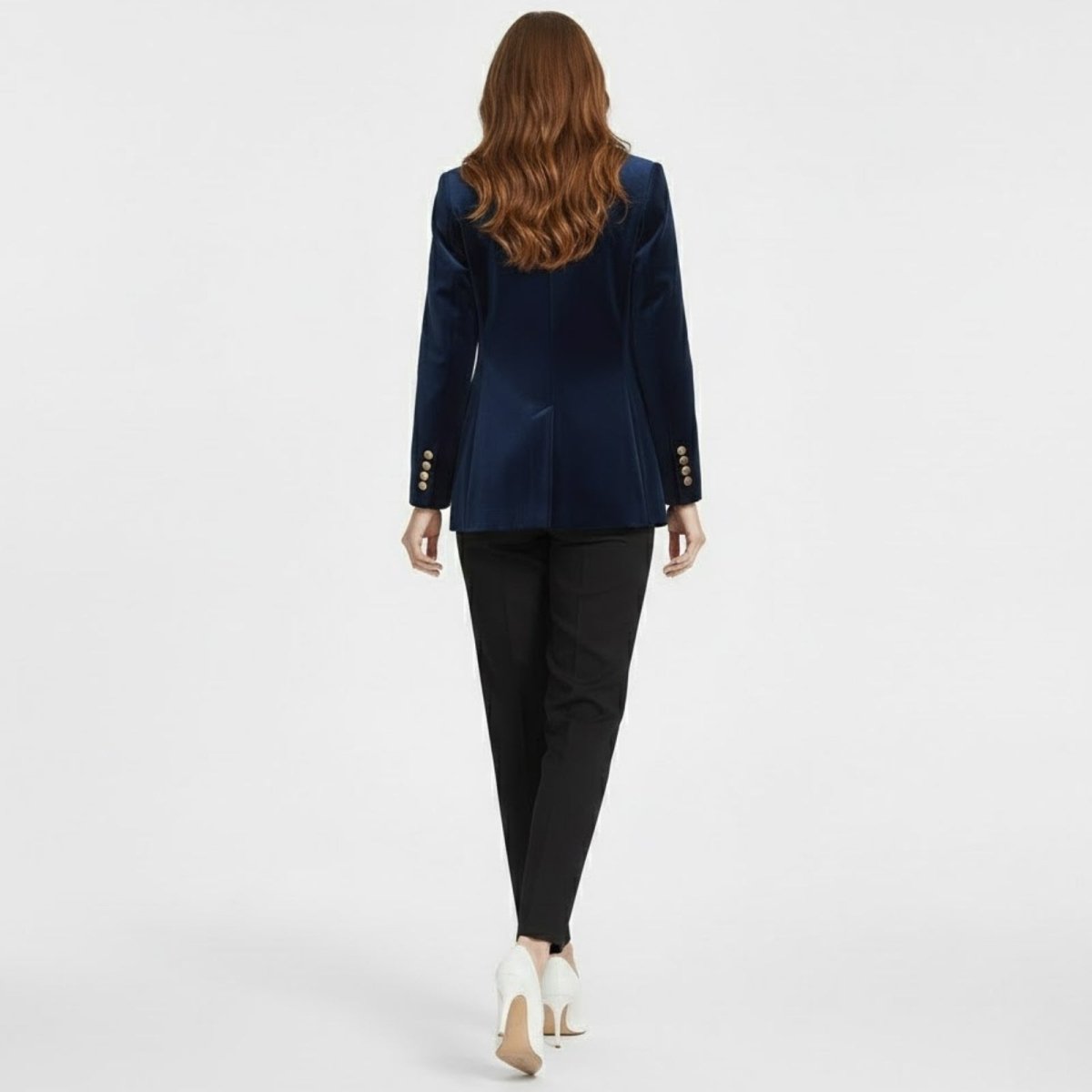 Back view of a female model wearing the Kouvr Fashion blue velvet blazer, highlighting the single back vent and structured silhouette.
