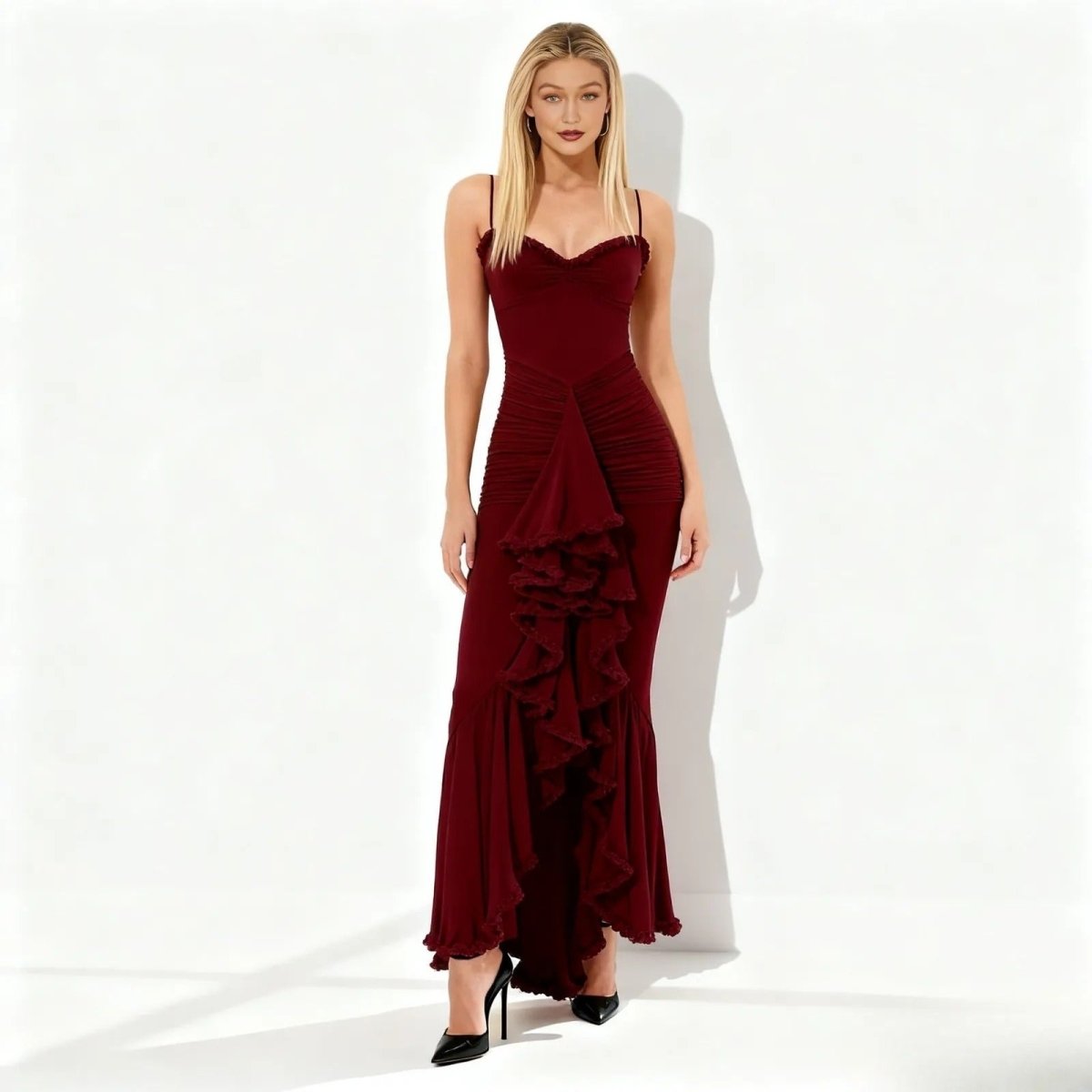 Woman wearing a maroon evening gown with ruffled layers on a white background