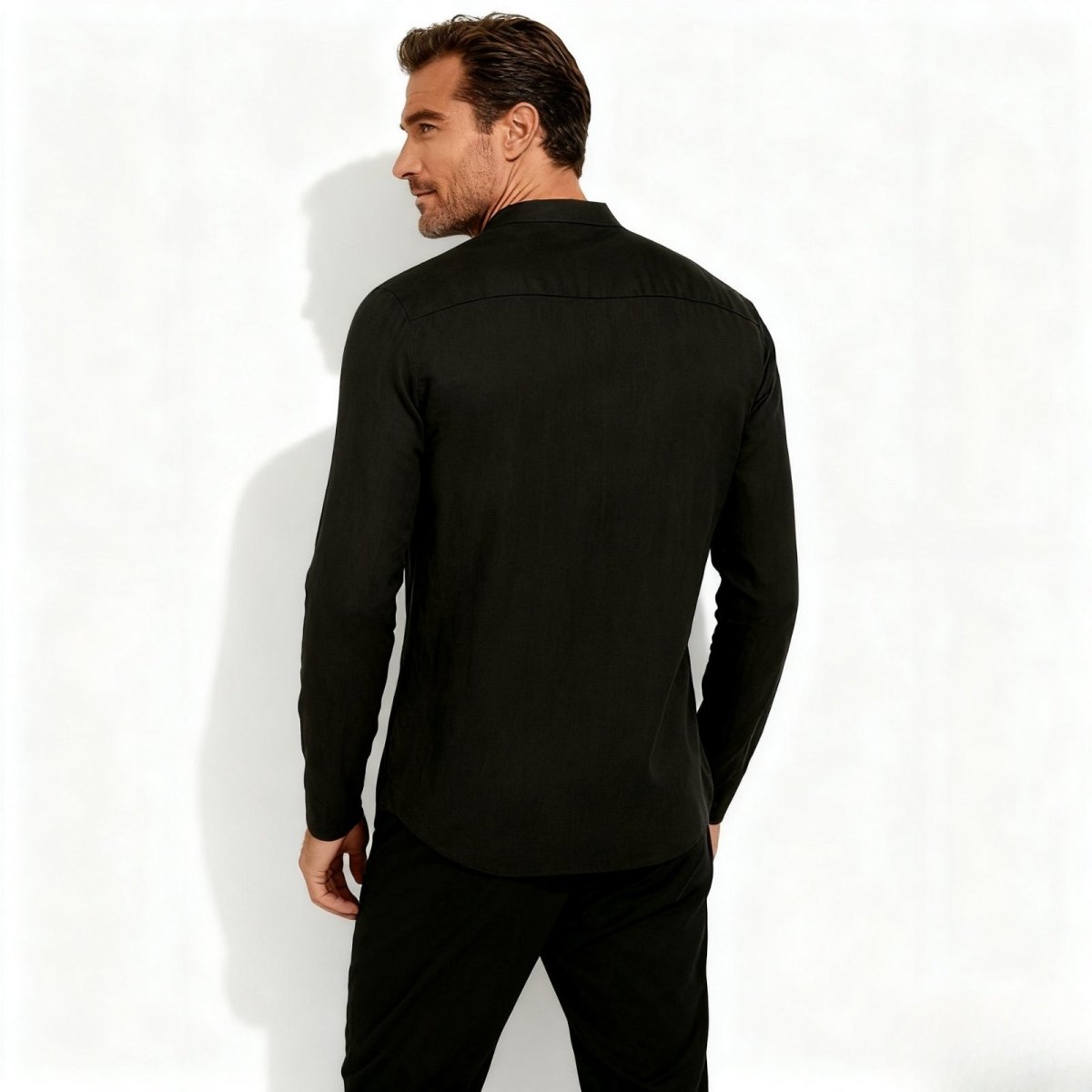 Back view of a male model wearing the Kouvr Fashion black linen shirt, showing the shoulder yoke and tailored construction.