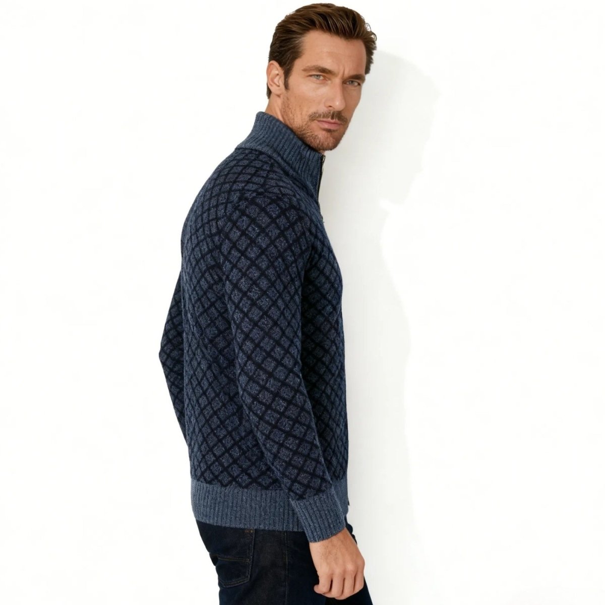 Side profile of a man wearing the navy diamond jacquard knit zip sweater from Kouvr Fashion against a white background.
 