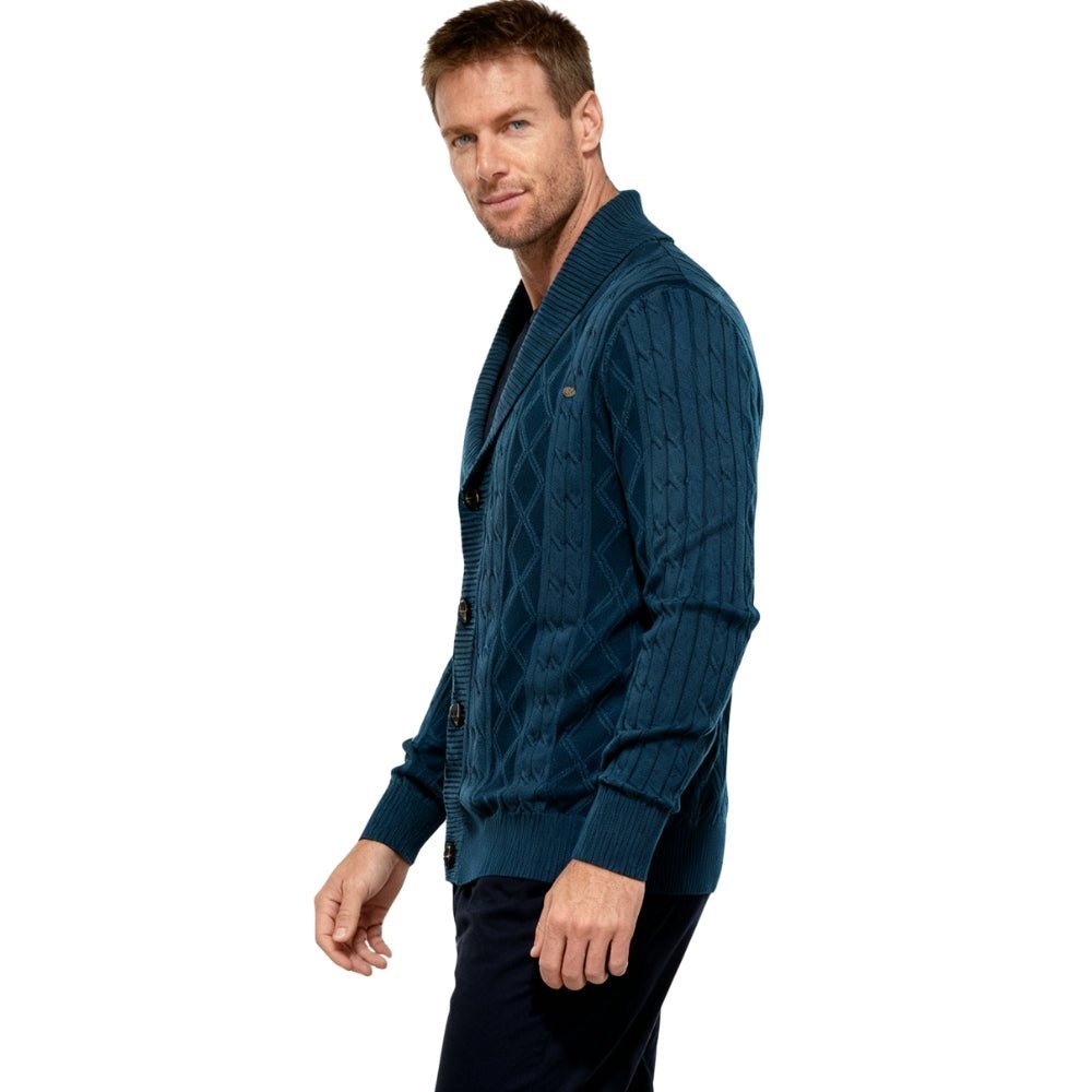 Man wearing a blue kouvr  cable knit cardigan on a white background