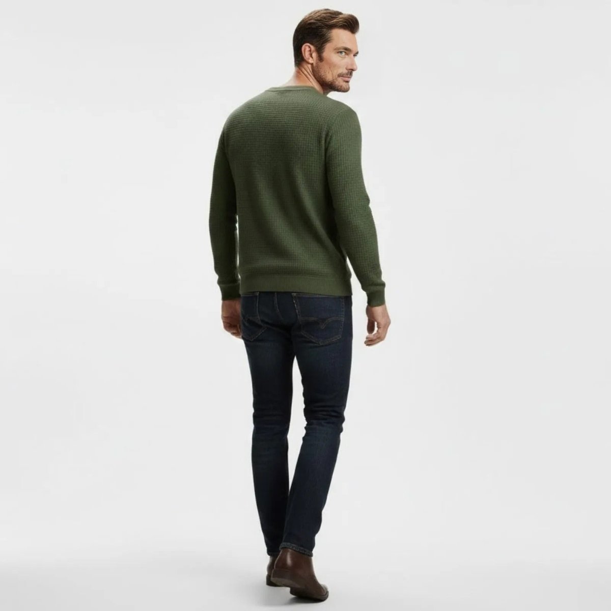Back view of a male model walking away wearing the Kouvr Fashion olive green waffle knit pullover sweater.
