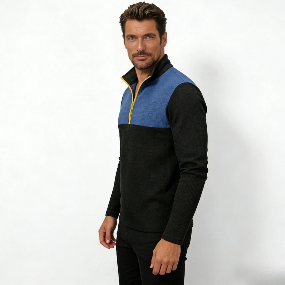 Model from a side angle wearing the slim fit blue and black waffle-knit quarter-zip sweater by Kouvr Fashion.