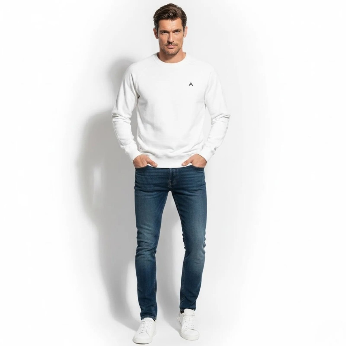 Man wearing the Kouvr Fashion white raglan sleeve crewneck sweatshirt with dark blue jeans.