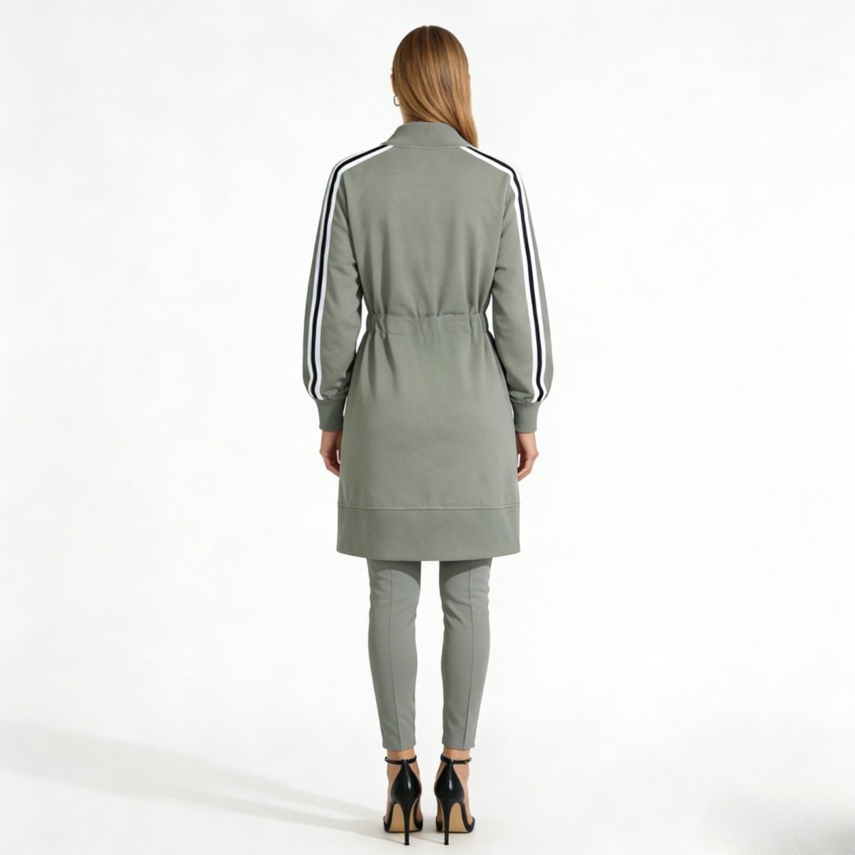 Back view of a model in the grey Kouvr Fashion duster jacket, showing the sleeve stripes and the sleek, longline silhouette.