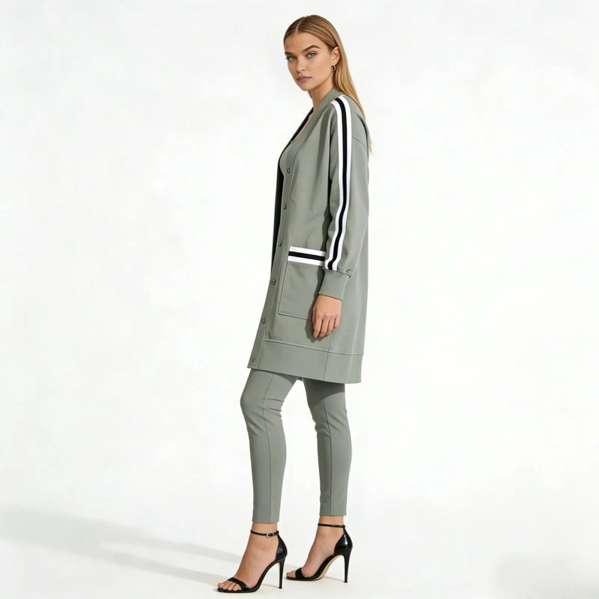 Side profile of a model wearing the Kouvr Fashion grey duster jacket, highlighting the black and white varsity stripes on the sleeve.