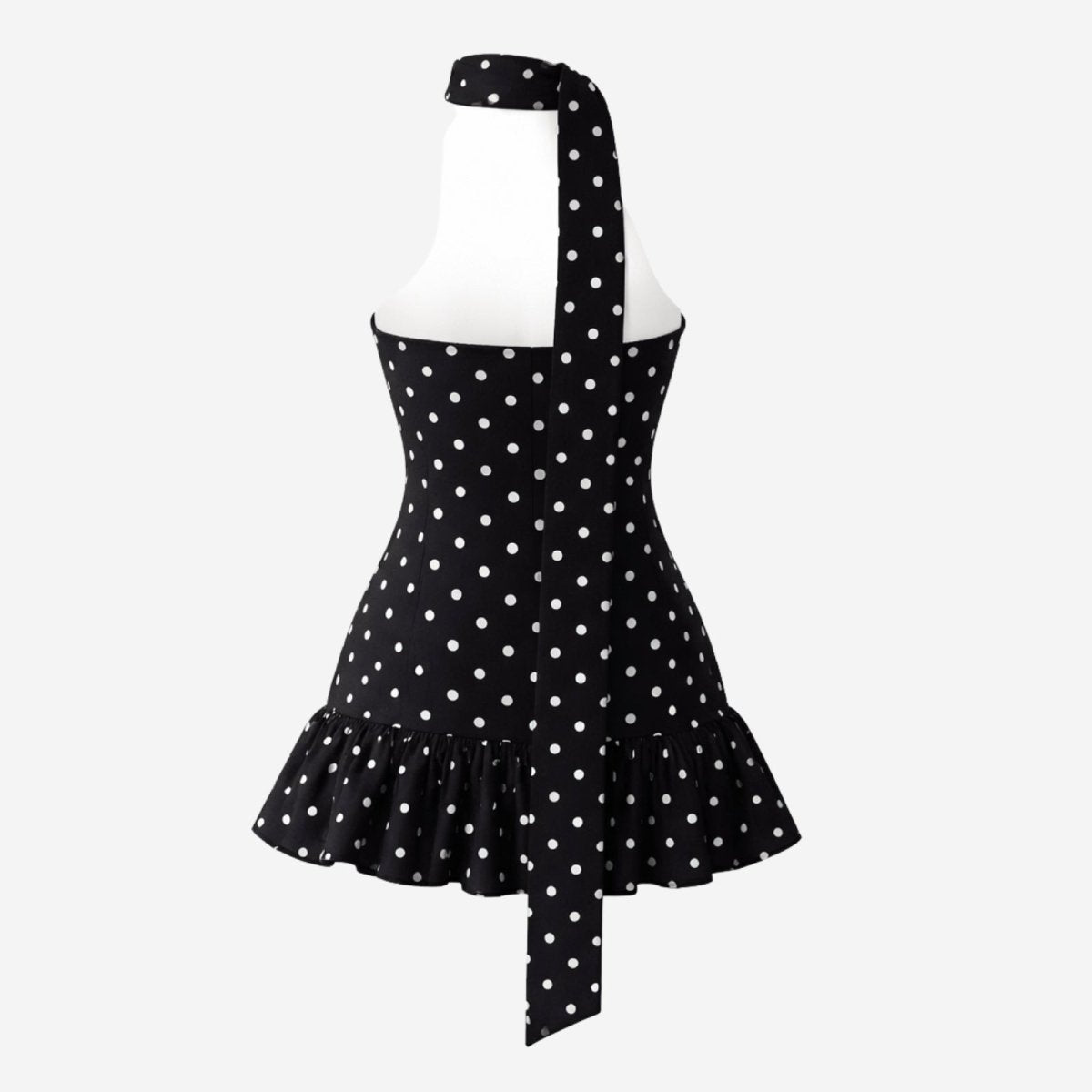 Flatlay of the back of the polka dot halter dress displaying the open back design and long neck sash.