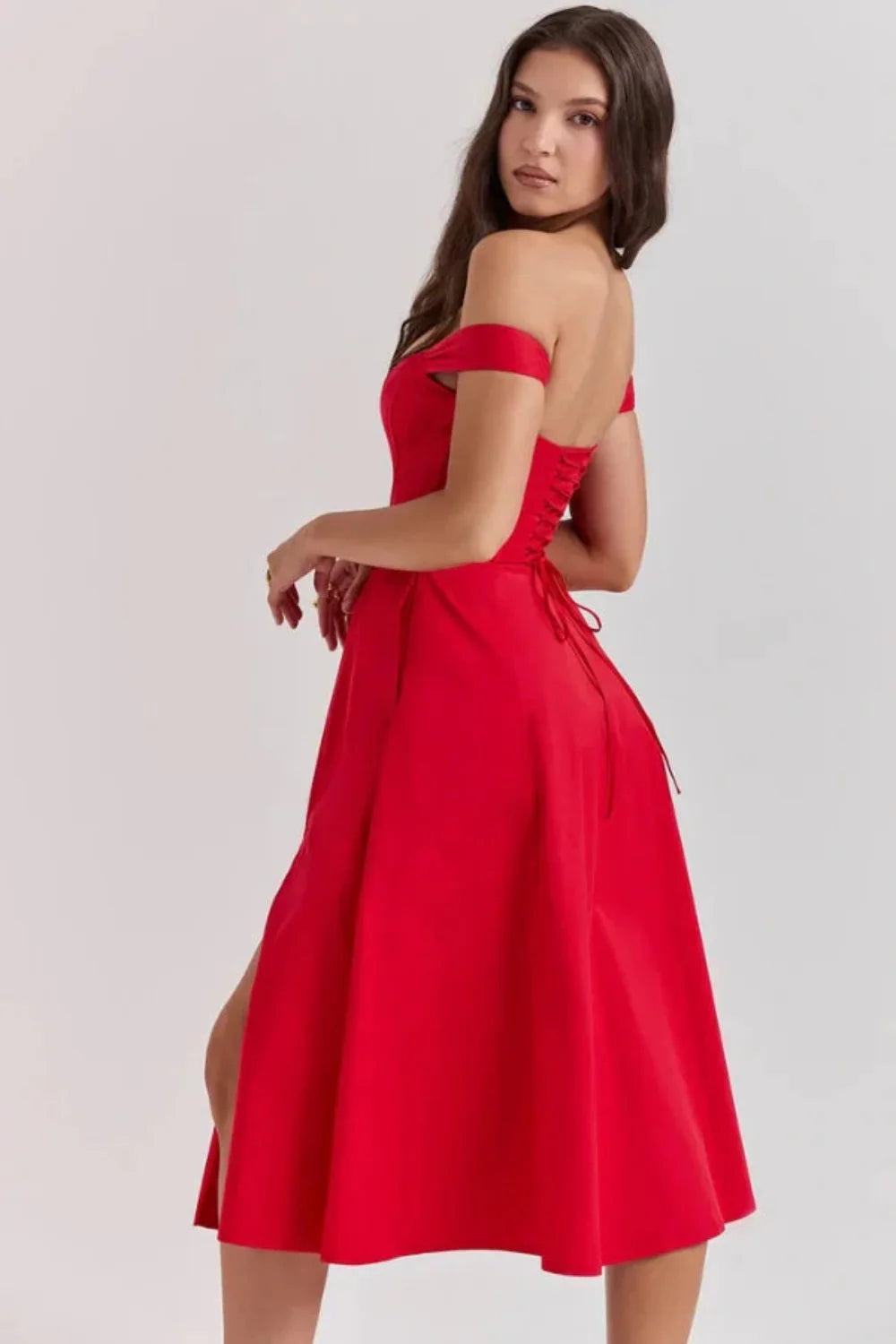 Bardot neckline, bustier dress, A-line skirt, thigh-high slit, lace-up back, wedding guest attire, structured bodice, statement dress