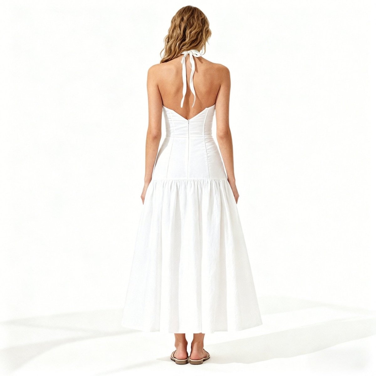 Woman wearing a white halter neck dress on a white background