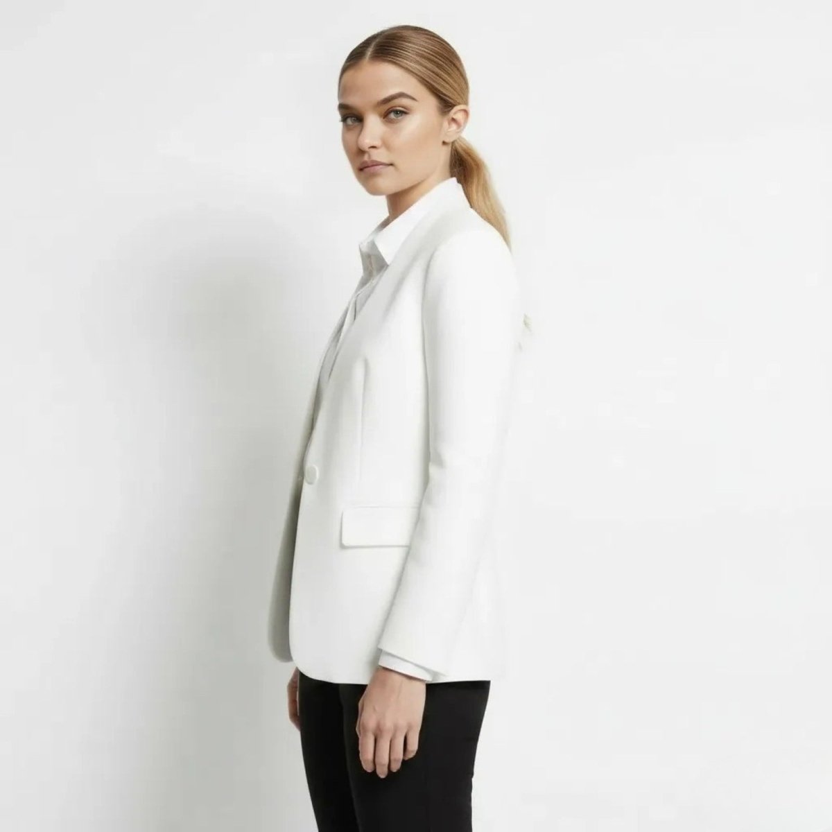 Side profile of a model in the Kouvr Fashion classic white blazer showcasing its tailored fit and structure.