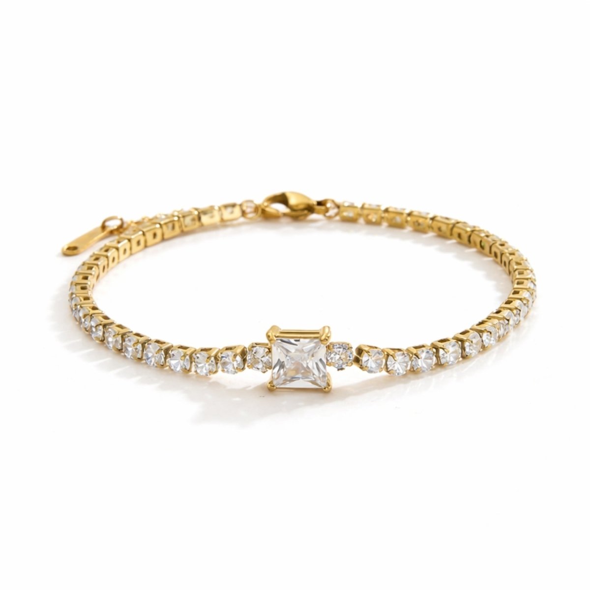 Kouvr gold tennis bracelet with a square princess cut center stone on a pure white background.