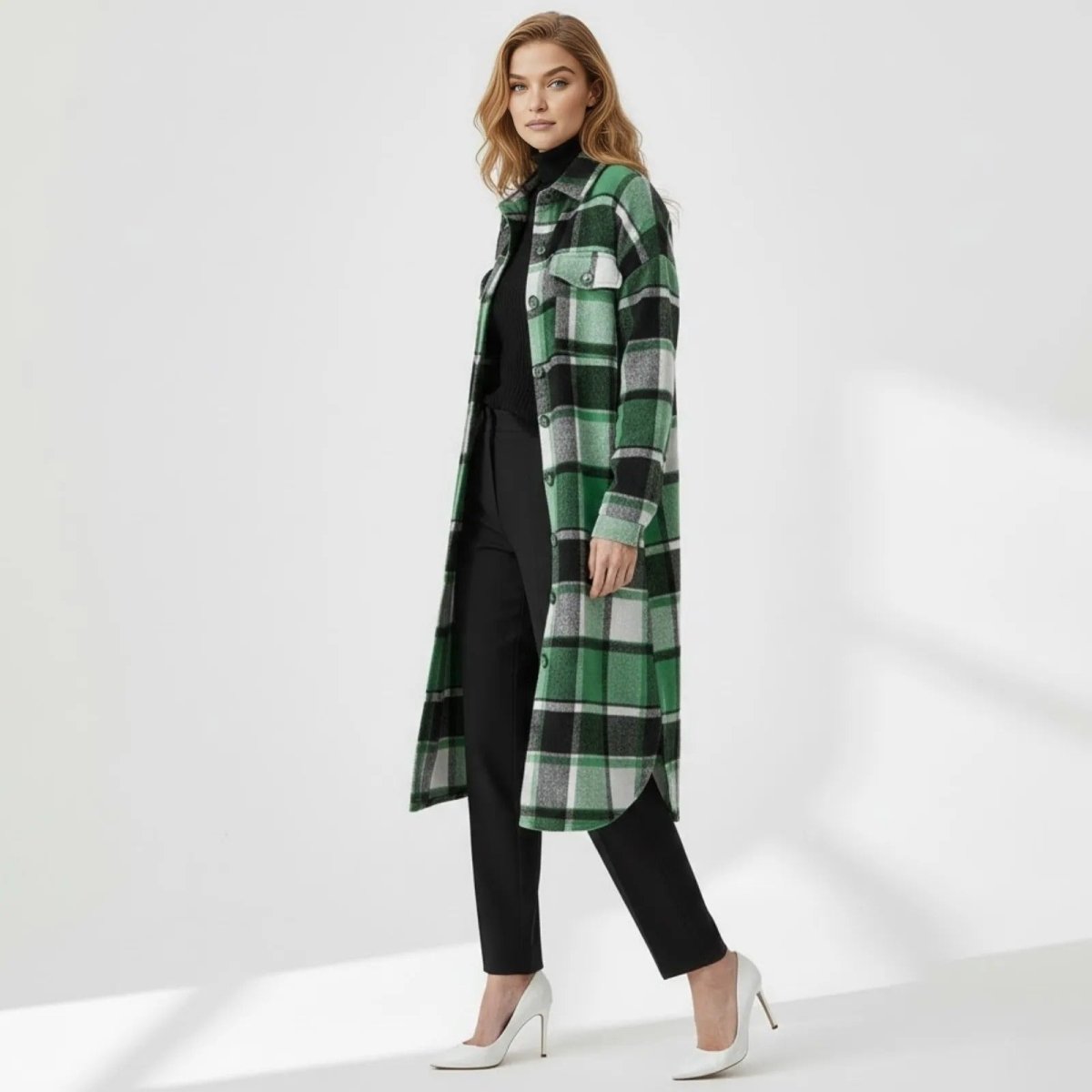 Side profile of a model wearing the Kouvr oversized green plaid shacket, showcasing its longline silhouette and curved hem.