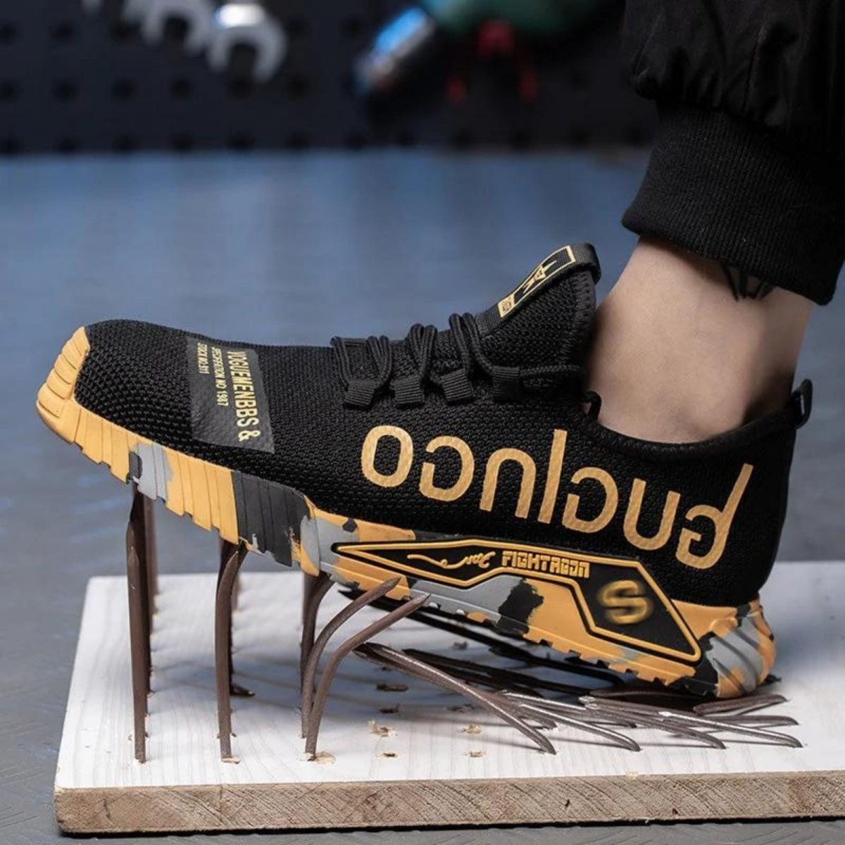 Black and yellow Kouvr sneaker with branding on a stand