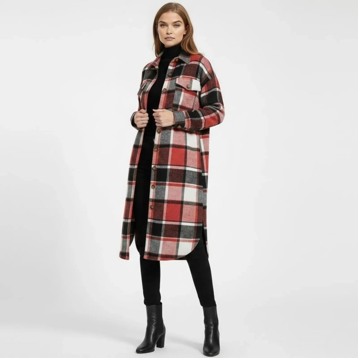 Model facing forward wearing the Janet long plaid shacket in red, black, and white, styled open over a black turtleneck and leggings with black ankle boots.
