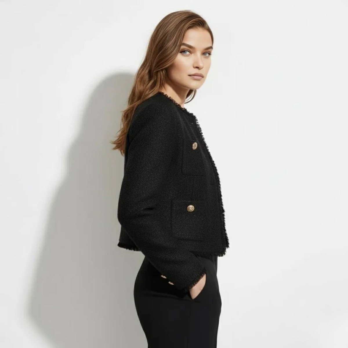 Side profile of a model in the Kouvr Jelani Black Tweed Jacket, highlighting the cropped fit and textured boucle fabric.