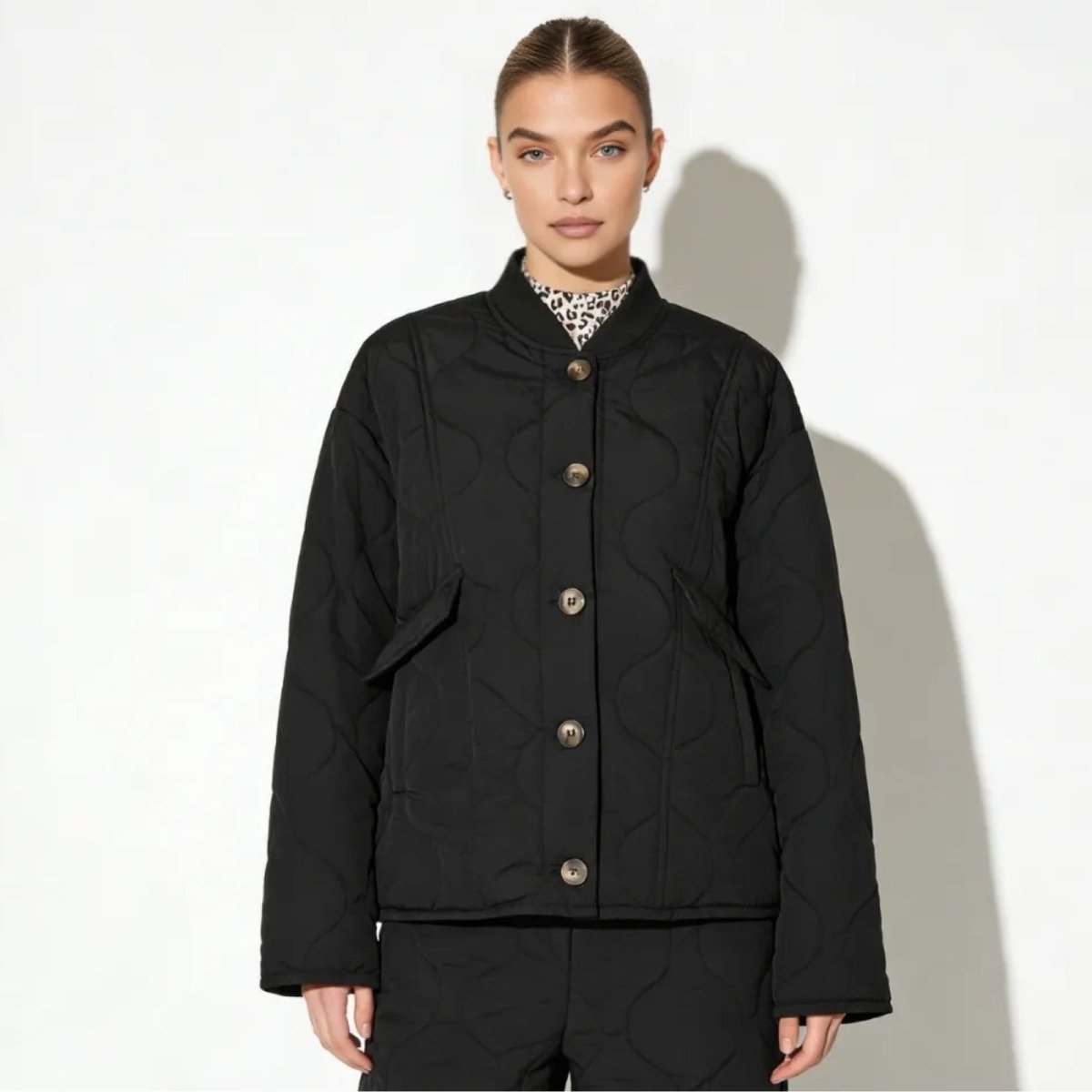 Model wearing the Kouvr Jennalyn black oversized quilted liner jacket with a leopard print collar, shown from the front against a white background. 