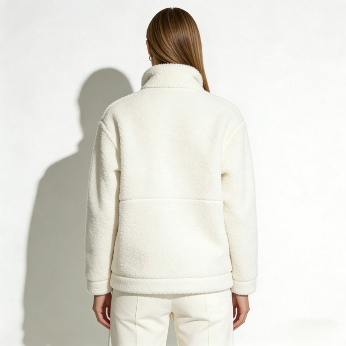 Rear view of a model wearing the Kouvr Julie full-zip fleece jacket, highlighting the back paneling detail.
