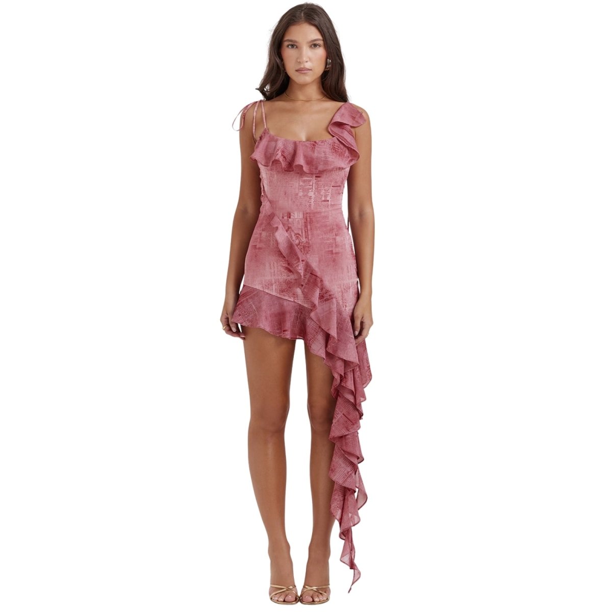 Woman wearing a pink print kouvr  ruffled dress on a white background