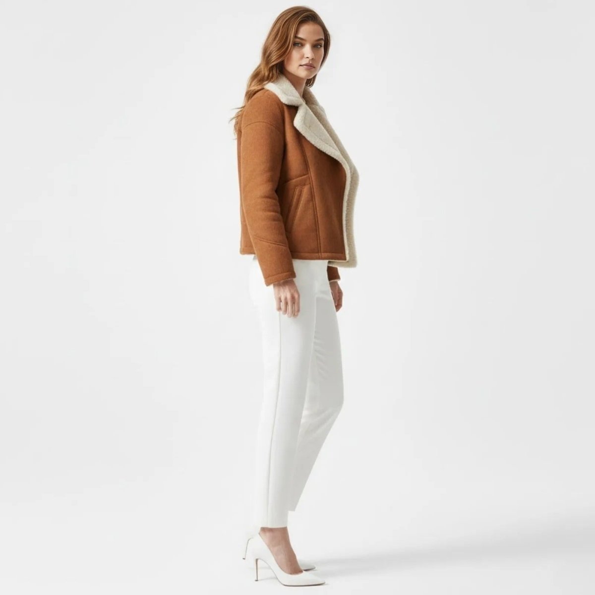 Side profile of a woman in a brown faux suede sherpa-lined jacket from Kouvr, showing the jacket's fit and length.